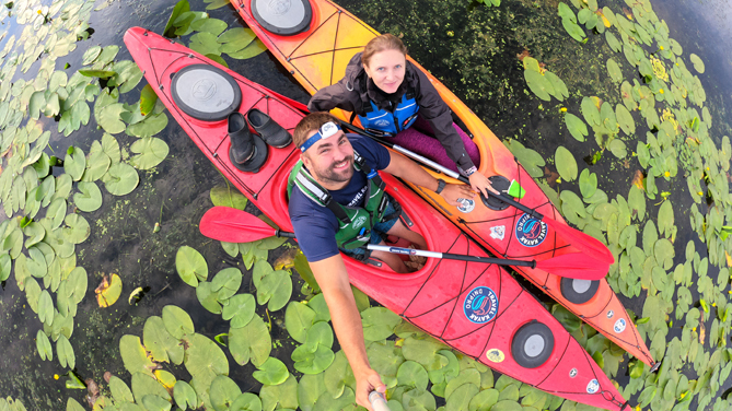 Go-pro foto kayaking. Парень с девушкой улыбаются в одноместных каяках. Фото на селфи палку.